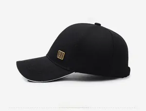 Detail of black cotton baseball cap with gold metal side plaque and white brim piping