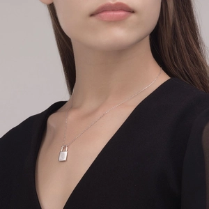 Elegant S925 sterling silver padlock necklace worn by a model on a minimalist grey background