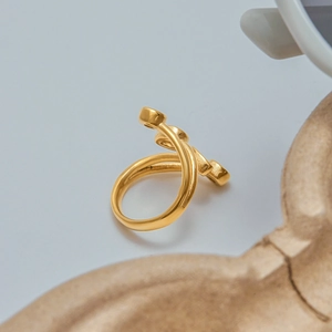 Detailed view of the gold-plated spiral ring featuring a matte finish and triple disc accents