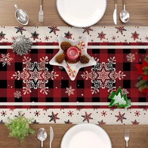 Detailed close-up of a red and black buffalo plaid Christmas table runner with snowflake design