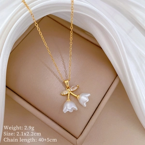 Detail of bell flower pendant necklace in gold with size and weight specs on silk