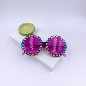Fashionable purple round kids sunglasses with colorful rhinestones on a stylish display