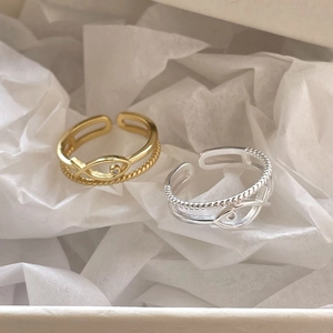 Detail view of gold and silver double-layered rings with hollow fish design and crystal