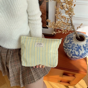 Detail of yellow and blue striped canvas makeup bag with premium cotton texture