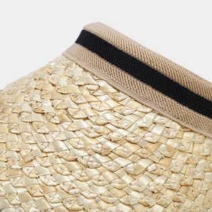 Macro detail of natural straw weave texture and striped elastic band on a sun visor hat