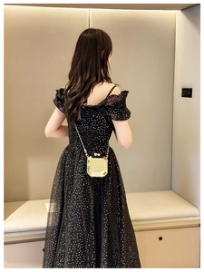 Close-up of a gold octagonal metal chain bag paired with a black sequin evening dress