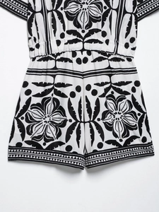 Detail of black and white tropical floral print romper with elastic waist and woven texture