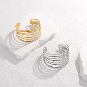 Close-up of gold and silver multi-layer stainless steel bangles on stone base