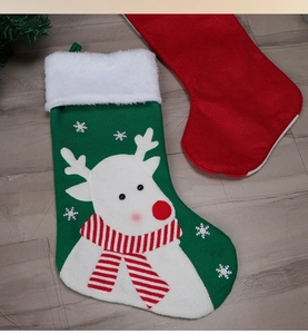 Close-up of green and red felt Christmas stockings with reindeer and snowflake motifs