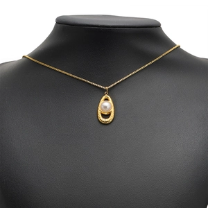 Stainless steel gold necklace with hollow oval pendant and centered white pearl on mannequin