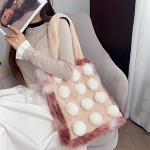 Detail der Plüsch-Tragetasche aus beige Stoff mit rosa Kunstpelzbesatz und weißen Pompons