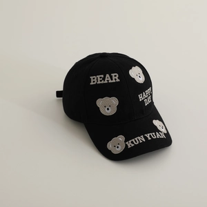 Close-up of intricate bear embroidery and 3D patches on black cotton baseball cap