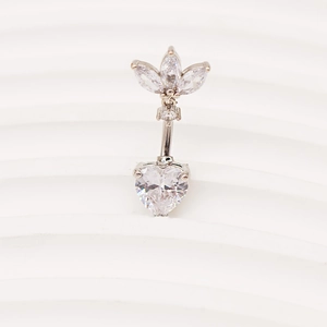Détail macro du piercing d'ombilic en argent avec zircon coeur et cristaux clairs