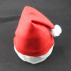 Detailed close-up showing texture of red brushed fabric and white plush pom-pom on Christmas hat