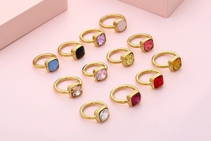 Detail view of square-cut zirconia rings in twelve various colors with gold plating