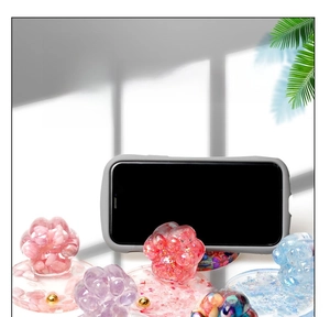Detailed view of cat paw phone stands made of resin with colorful crystal stones
