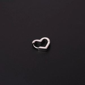 Vue macro d'une boucle d'oreille en forme de cœur en acier inoxydable poli brillant