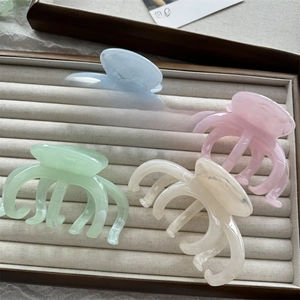 Detail of four colorful macaron ink-textured hair claws on a velvet display tray