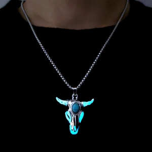 Luminous bull skull pendant with turquoise stone glowing blue on a male model