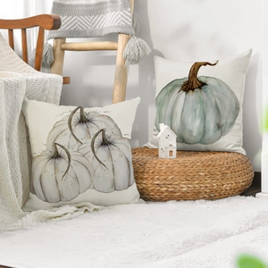 Close-up of linen blend pillow covers with harvest pumpkin prints in a cozy autumn setting