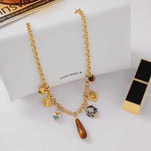 Detailed close-up of gold titanium steel necklace with resin charms and ceramic beads