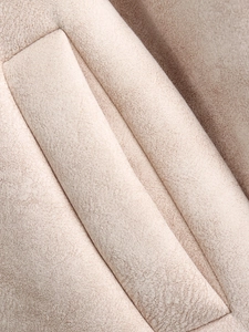 Detailed macro view of quilted beige suede fabric texture with warm padded stitching