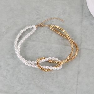 Detail of faux pearl and golden bead spliced necklace with lobster clasp and chain