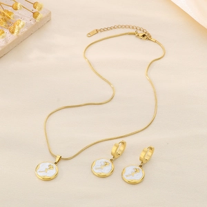 Detail of gold necklace and earrings set with white shell inlay and 3D rose pattern