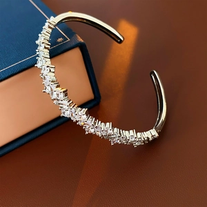 Gros plan sur un bracelet jonc argenté avec des pierres de zircone au style irrégulier