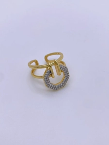Close-up of gold-plated geometric hexagonal ring with clear zircon stones on white background