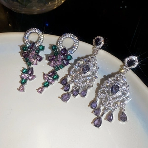 Detail of luxury drop earrings with colorful zircon stones and intricate silver patterns