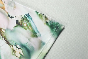 Macro detail of breathable mesh fabric featuring green marble tie-dye print and stitching