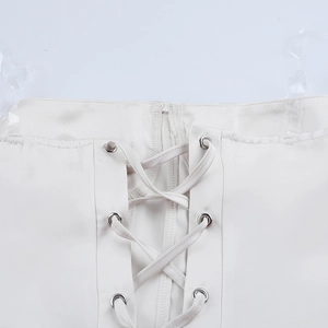 Détail macro du corset en satin blanc avec laçage croisé et œillets métalliques