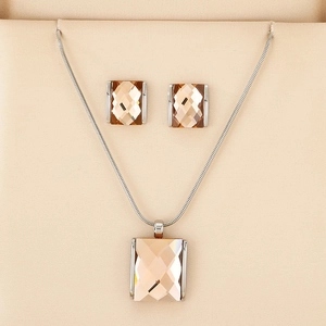 Detail of luxury champagne square-cut crystal pendant necklace and earrings set in silver