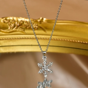 Macro shot of silver snowflake pendant with sparkling crystals on a golden frame