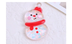 Macro detail of transparent resin snowman charm with glitter and red scarf for DIY crafts