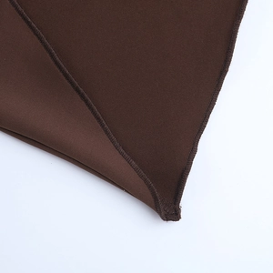 Makroaufnahme von dunkelbraunem Kleiderstoff mit präzisen Nähten und Saumdetails