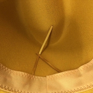 Detailed interior of mustard wool felt fedora showing pink sweatband and adjustable drawstring