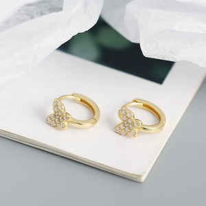 Macro shot of gold butterfly hoop earrings with sparkling crystal accents for women