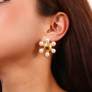 Close-up of 18K gold plated radial stud earring with pearls on female model's ear