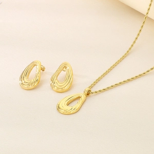 Detail of gold water drop spiral pendant necklace and matching stud earrings set
