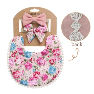 Detailed view of floral cotton baby bib set with bow headbands and white lace trim