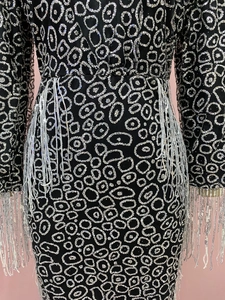 Detail of silver sequin pattern and elegant fringe trim on a slim fit party dress