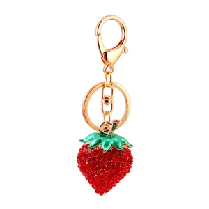 Sparkling strawberry keychain with red rhinestones and golden metal ring on white background
