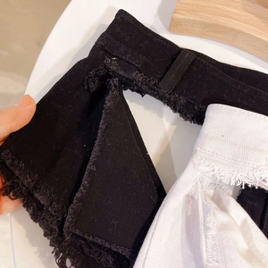 Détails de shorts en jean avec découpes à la taille et finitions d'ourlet effiloché