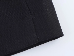 Dettaglio del mini abito nero che mostra la trama del tessuto e le cuciture rifinite