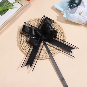 Elegante fiocco regalo in nastro nero e organza su sfondo rustico in paglia intrecciata
