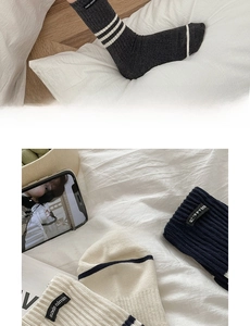 Detail of ribbed knit crew socks with white stripes in grey, beige and navy colors