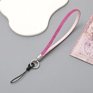 Detail of pink rhinestone phone strap with white leather backing and silver metal clasp