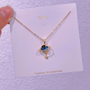 Dettaglio del ciondolo pianeta con pietra nebulosa blu e charm a stella dorata